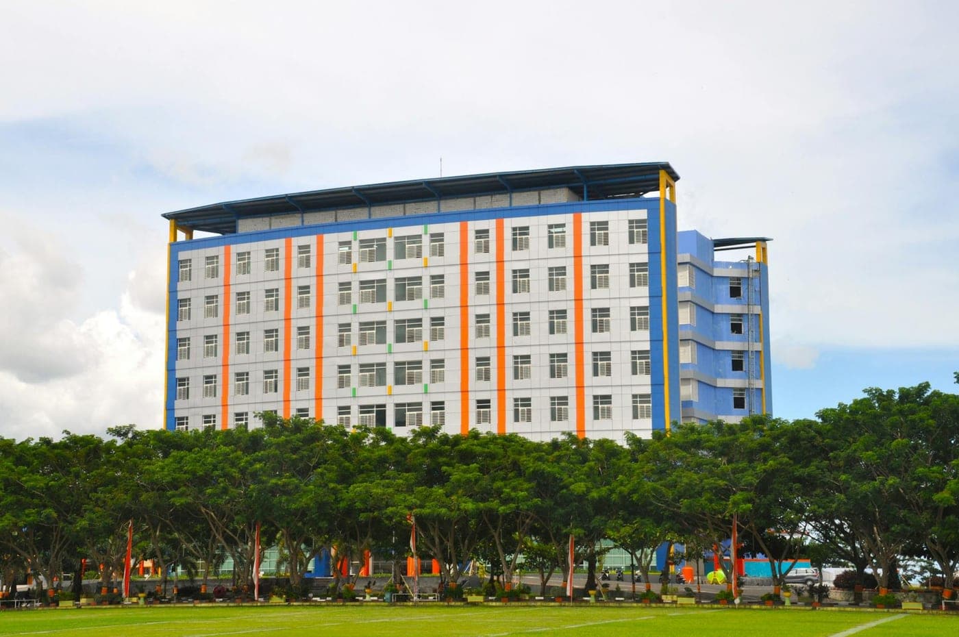 Gedung asrama kampus bertingkat dengan aksen warna oranye