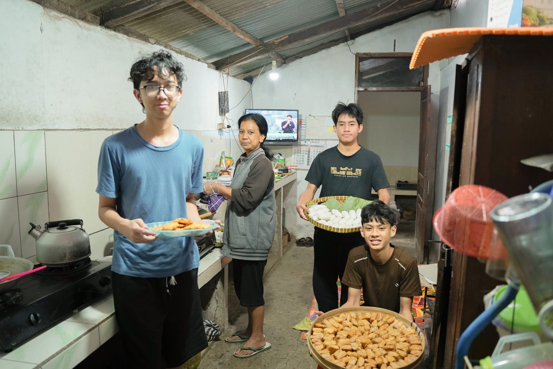 Siswa menyajikan makanan di dapur rumah warga