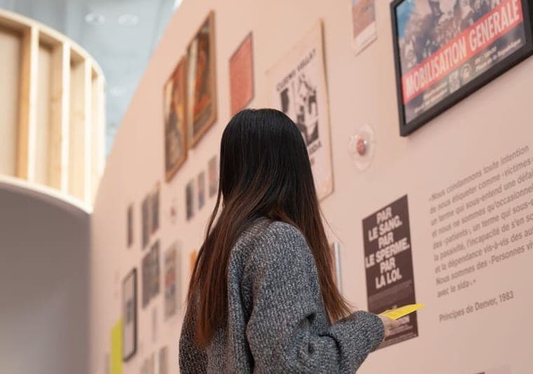 Pengunjung pameran mengamati panel informasi yang terpasang di dinding ruang ekshibisi